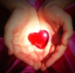 two-hands-holding-a-glowing-heart