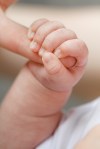 Close-up of baby’s hand holding mother’s&nbsp;finger